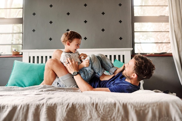 cheerful father playing with son at home
