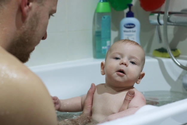 Photo cheerful father and son taking bath at bathroom