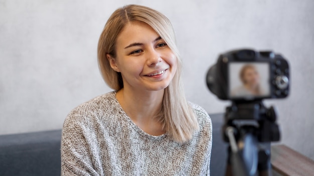 Photo cheerful female blogger recording video at home