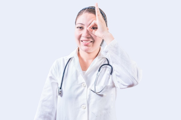 Cheerful female doctor gesturing approval isolated Young female doctor approving with finger on isolated background