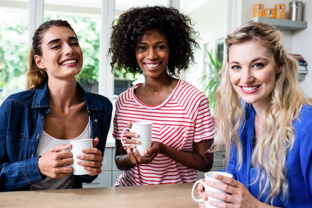 Cheerful female friends drinking coffee