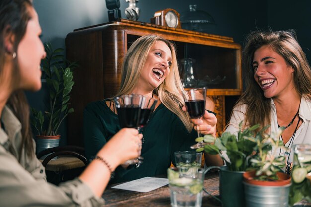 Photo cheerful female friends eating food at table in restaurant