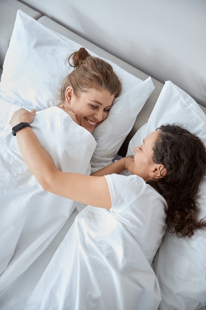 Cheerful female keeping smile on her face while listening to her partner