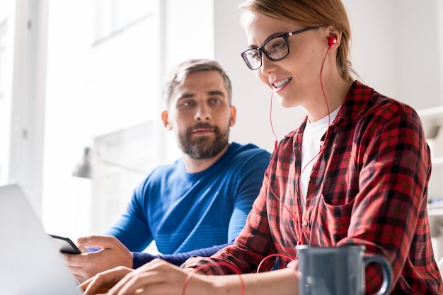 Cheerful female programmer focusing on coding