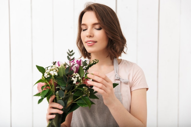 Cheerful florist woman standing with flowers