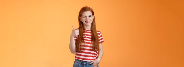 Foto la pelle pulita dei capelli naturali rossi della donna amichevole allegra mostra il pollice in su il sostegno sorridente di approvazione perfetto c