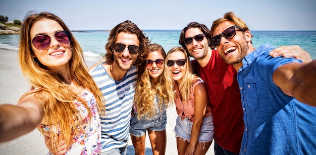 Cheerful friends at beach on sunny day