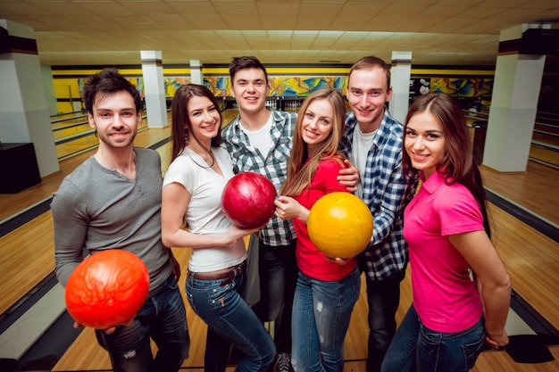 Foto amici allegri alla pista da bowling con le palle.