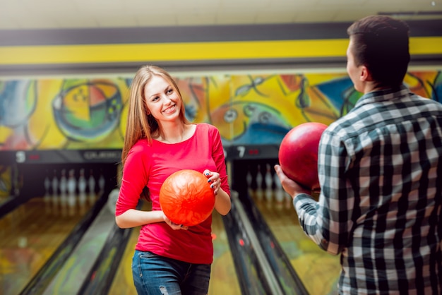 Cheerful friends at the bowling alley with the balls.