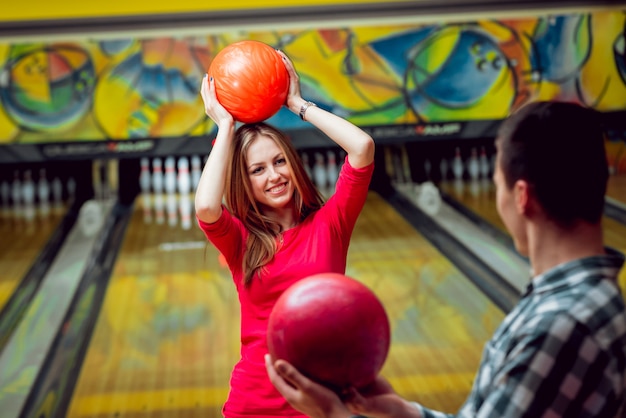 Cheerful friends at the bowling alley with the balls.