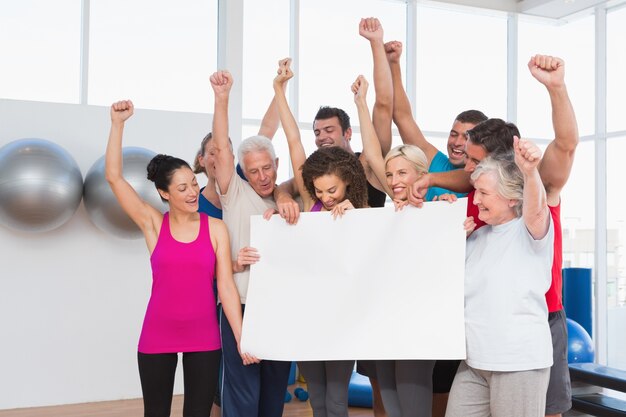 cheerful friends holding blank together 