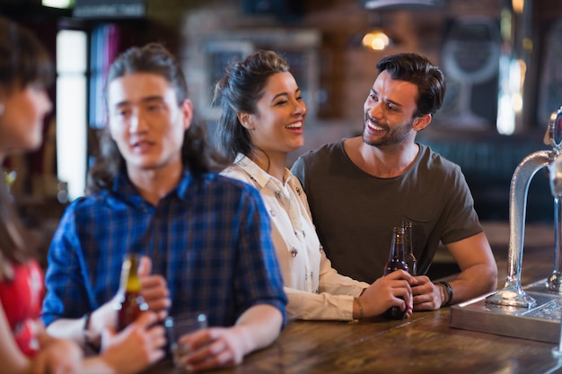 Cheerful friends interacting at bar counter