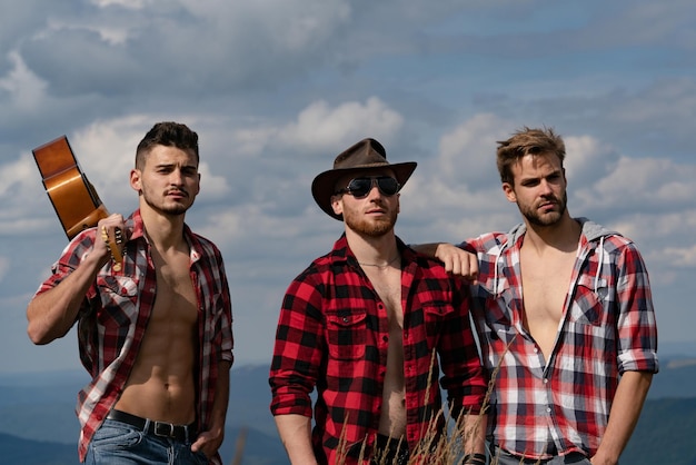 Foto amici allegri che ridono mentre si fa un'escursione con la chitarra gruppo di escursionisti in montagna escursionisti che si rilassano sulla cima di una montagna e si godono la vista della valle