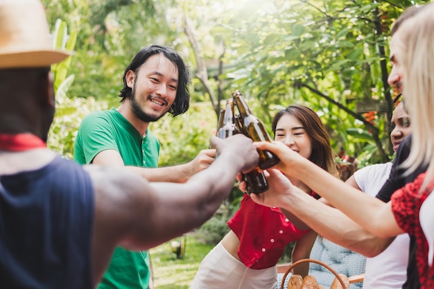 Photo cheerful friends toasting beers while standing outdoors