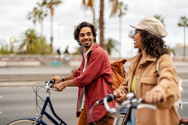 Cheerful friends walking on the street with bicycles