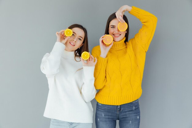 cheerful funny comic positive nude natural pure girls having two pieces of orange