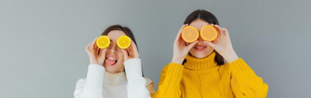 cheerful funny comic positive nude natural pure girls having two pieces of orange