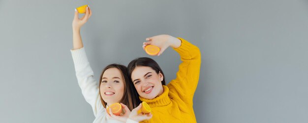cheerful funny comic positive nude natural pure girls having two pieces of orange
