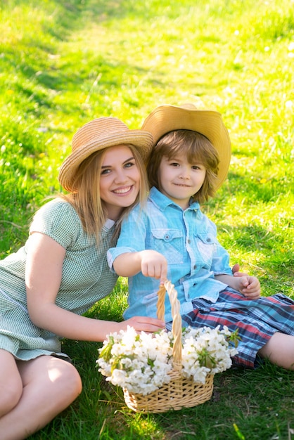 Веселая семья садовника, сидя во время пикника в саду. Молодая улыбающаяся семья, расслабляющаяся в солнечный день.
