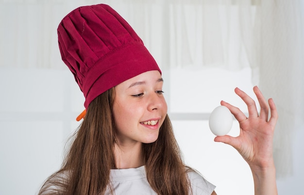 Cheerful girl holding egg for easter food