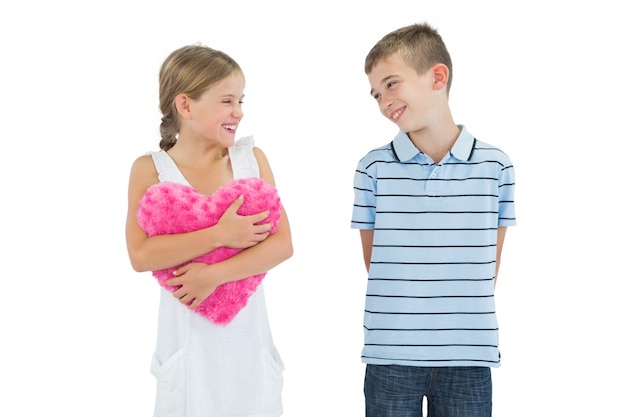 Cheerful girl holding heart shaped soft toy