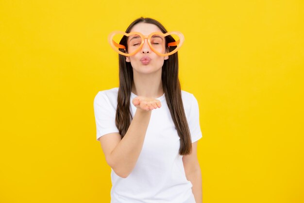 Cheerful girl in large bif funny party glasses sunglasses portrait of young woman wearing funny glasses isolated on yellow background