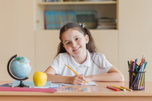 Photo cheerful girl looking at camera during lesson