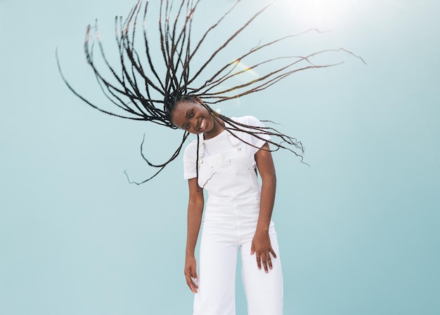 Photo cheerful girl looking at the camera and having fun with her long braids