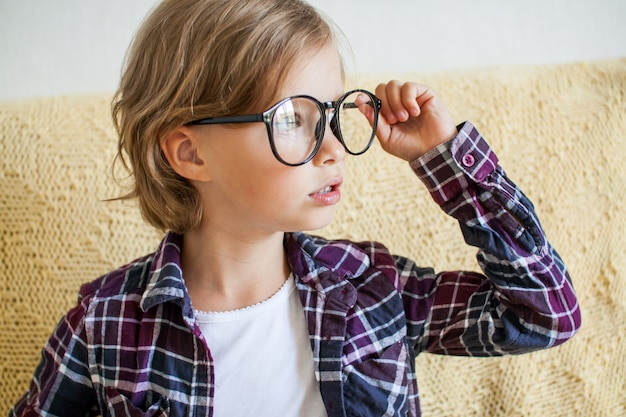 Foto ragazza allegra in una camicia a quadri e occhiali concetto di apprendimento online