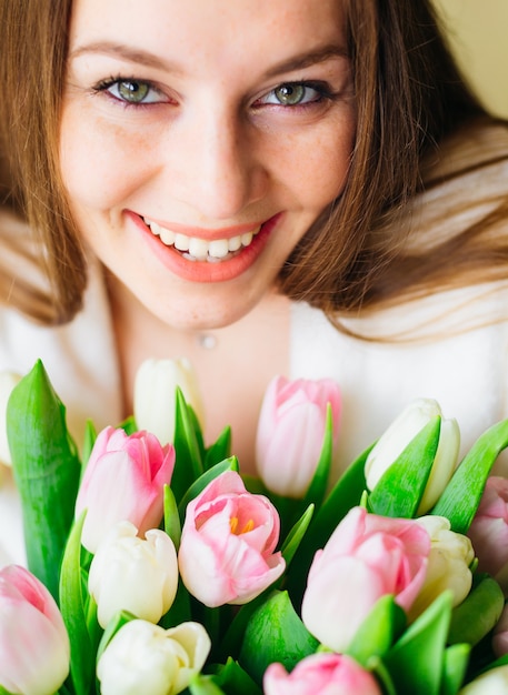 陽気な女の子は繊細なチューリップの大きな花束で喜ぶ。晴れた春の朝。自然の美。春の花嫁の花束。幸せな女性の日。