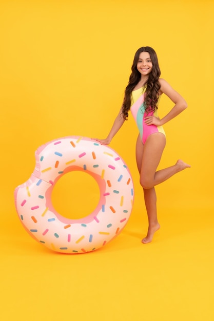 Веселая девушка в купальнике надувной пончик с кольцом для плавания