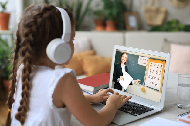 온라인 전자 학습 시스템을 통해 공부하는 노트북 컴퓨터를 사용하는 쾌활한 소녀