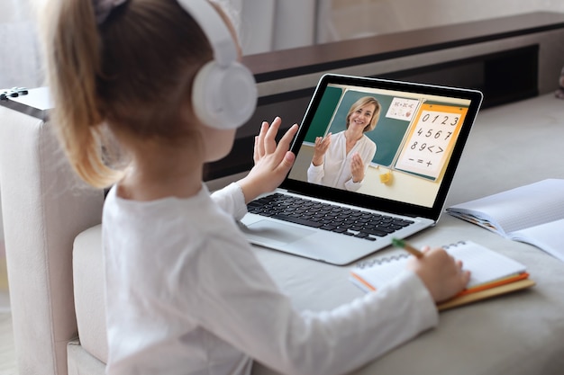 Foto ragazza allegra che utilizza il computer portatile che studia tramite il sistema di e-learning online