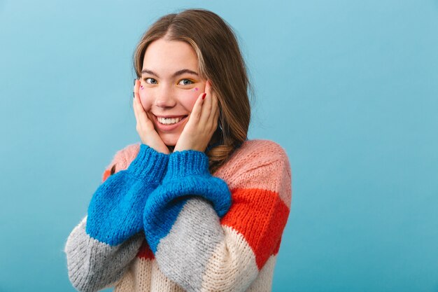 Cheerful girl wearing sweater standing isolated