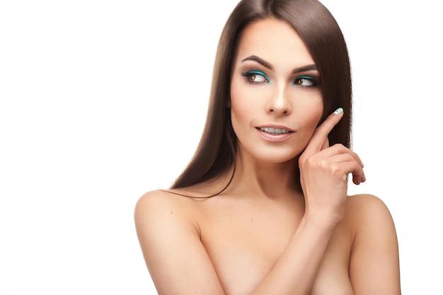 Cheerful girl with beautiful makeup and healthy skin looking aside in studio on white background