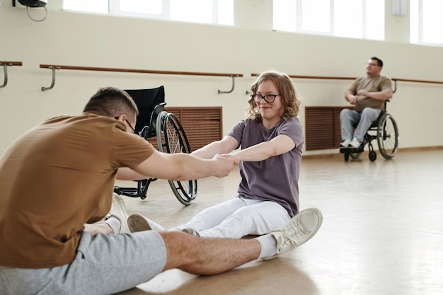 Cheerful girl with disability an her partner in dance studio