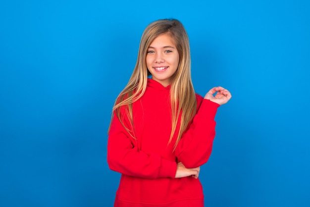 Cheerful girl with hand near face Looking with glad expression at the camera after listening to goo