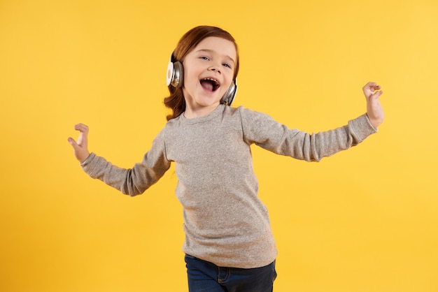 Cheerful girl with headphones listening to music.