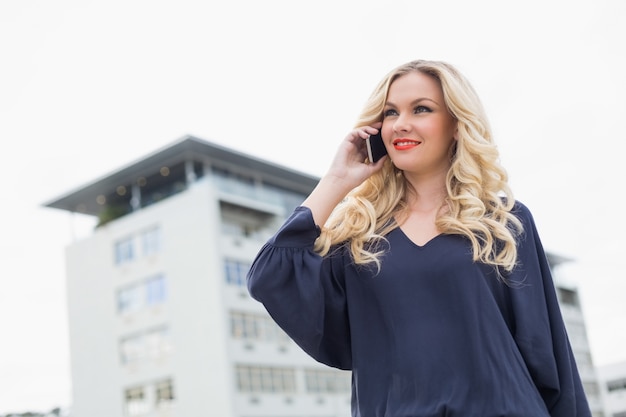 Foto bionda splendida allegra con le labbra rosse sul telefono