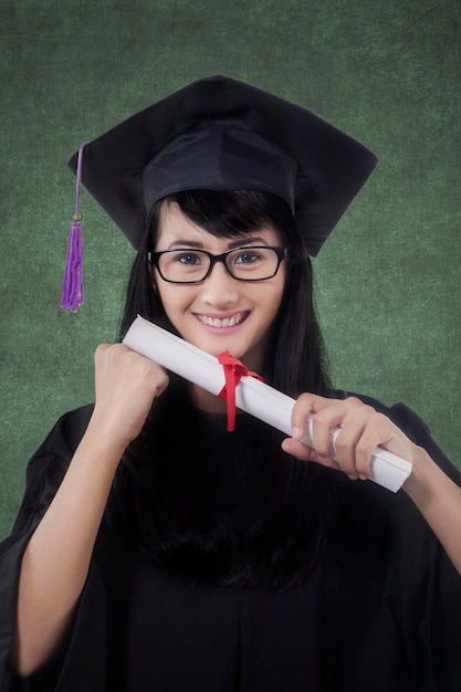 Cheerful graduate student holds a diploma