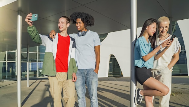 Cheerful group of friends looking smart phone surprised and excited outdoors smiling young people