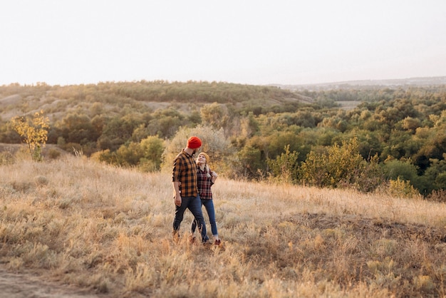 Cheerful guy and girl on a walk in bright knitted hats and plaid shirts