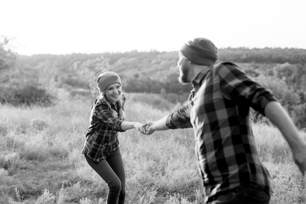 Cheerful guy and girl on a walk in bright knitted hats and plaid shirts