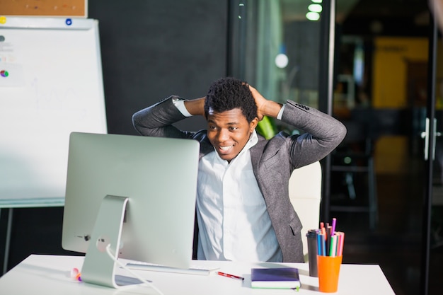 Ragazzo allegro uomo guarda felice al monitor di successo imprenditore libero professionista impiegato