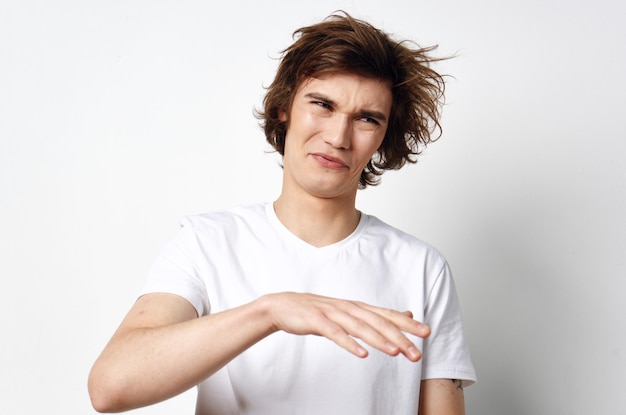 Cheerful guy with tousled hair in a white Tshirt emotions closeup