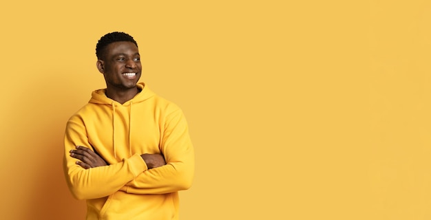 Cheerful handsome black guy looking at copy space panorama