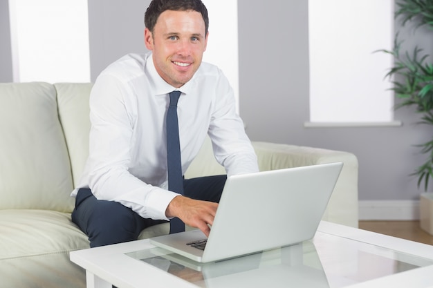 Cheerful handsome businessman working at laptop