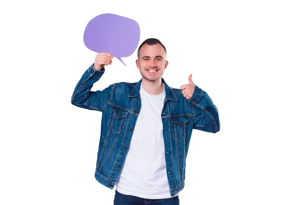 Cheerful handsome man in jeans jacket showing thumb up gesture and empty speech bubble