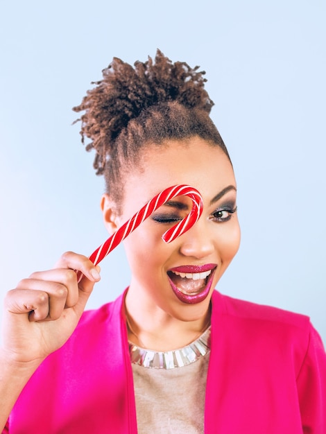 cheerful and happy afro american woman with candy cane