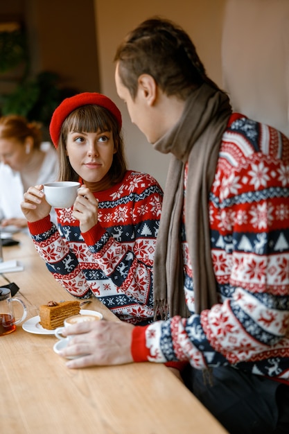 カフェでデートをしている陽気な幸せで美しい白人カップル